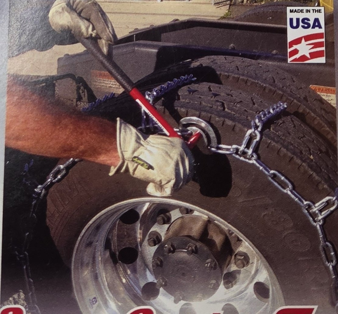 Red Super Combo Tool tightening a chain cam at a dual wheel with a polished aluminum rim