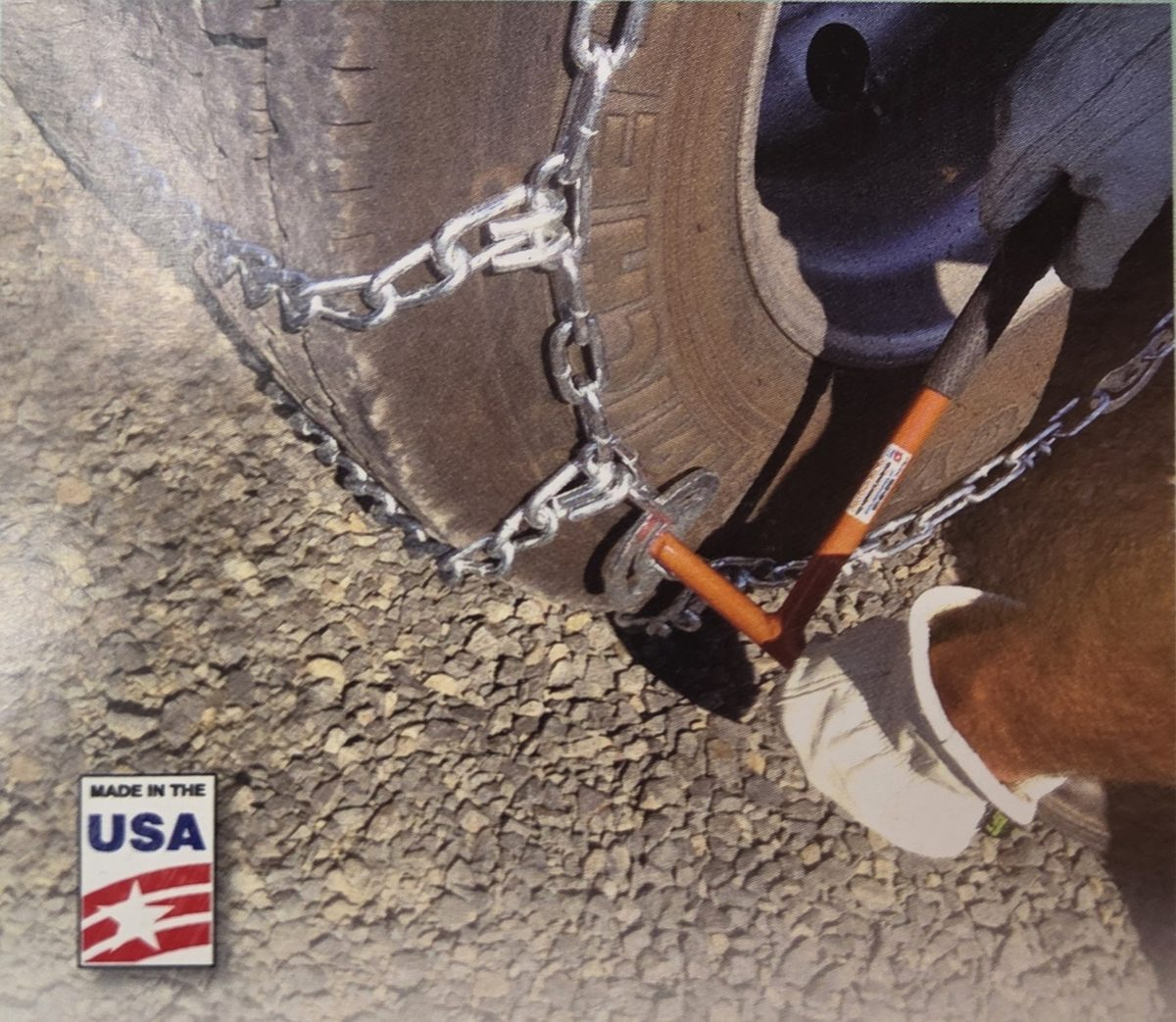 Gloved hand using the orange Super Mini Combo Tool on a Pewag style cam of a tire chain