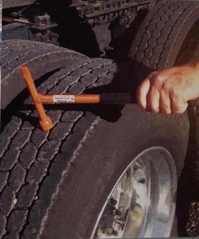 Orange Super Mini Combo Tool thumping a dual truck tire by hand