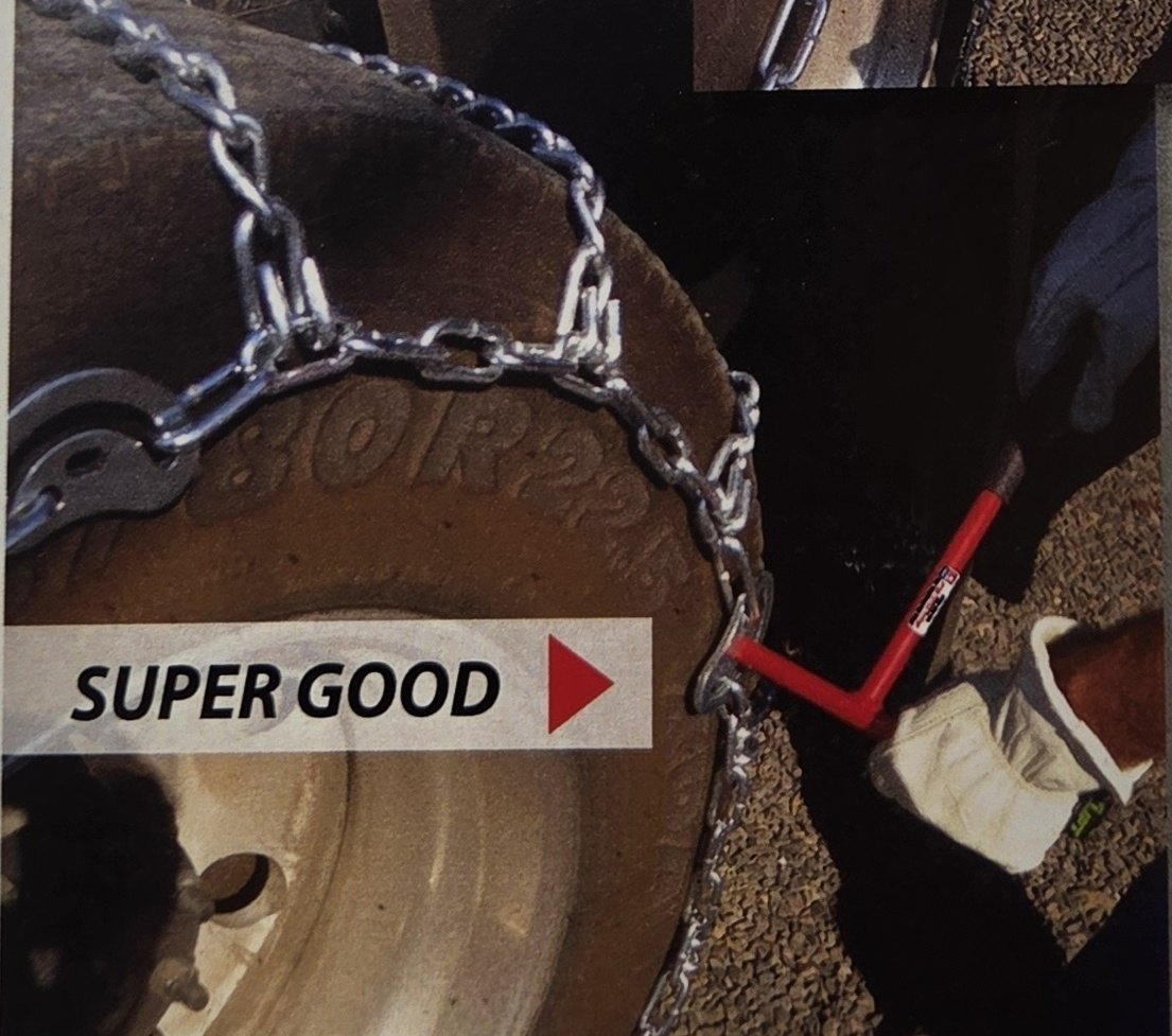 Super good: a red chain tool at the chain cam on a truck tire, one hand on the tool